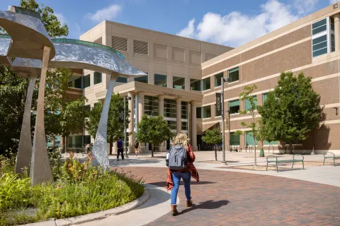 Student walking into Columbine Hall on UCCS Campus