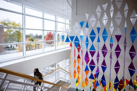 colorful artwork made from triangles of plexiglass hanging over the Ent bank in University Center