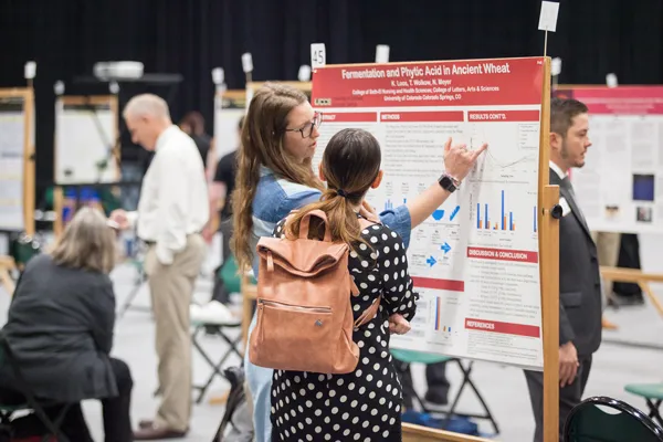 Students in Gallogly Events center presenting posters for CSURF